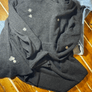 Custom sweater repair featuring hand-embroidered patches on a cozy dark sweater.