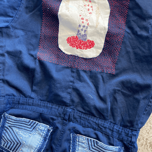 Custom woven embroidery repair on a navy blue garment featuring delicate hand embroidery.