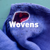 Close-up of blue fabric with 'Wovens' branding on a teal background