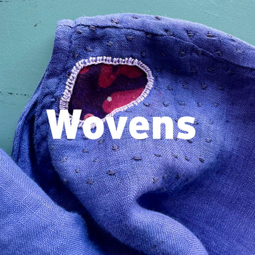 Close-up of blue fabric with 'Wovens' branding on a teal background