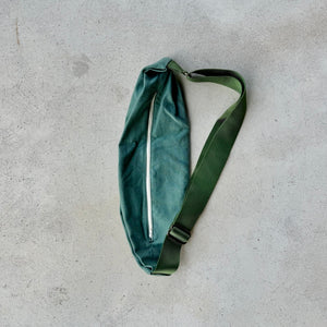 Green waist bag on a gray concrete surface